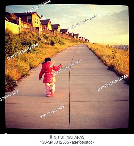 Suburbia - a child on a walk next to a row of houses in San Ramon, California, USA