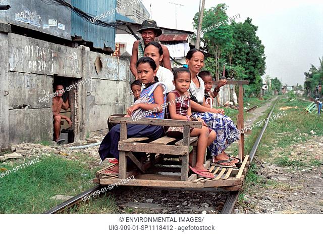 TRANSPORT, PHILIPPINES. Manila. Sucat Railway Community. Human powered railway taxi. . Young men ferry passengers along the track in makeshift wagons