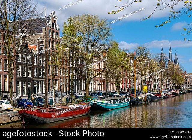 View of Amsterdam canal with historic houses and boat, Netherlands