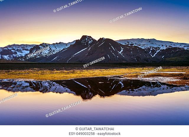 Winter mountains reflection at sunset in a lake