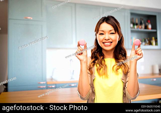 happy woman with macarons on kitchen