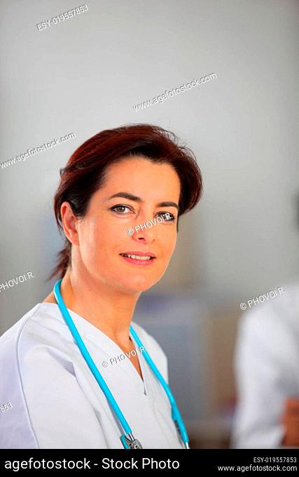 Portrait of a smiling woman in a white coat with a stethoscope around neck