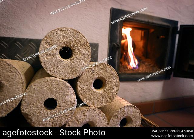 PRODUCTION - 08 November 2021, Bavaria, Kaufbeuren: A wood stove is heated from the hallway with wood briquettes. Photo: Karl-Josef Hildenbrand/dpa