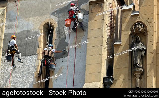 High-altitude workers (climbers) hanging on ropes repair the towers of St. Anthony's Church at Strossmayer Square in Prague, Czech Republic, June 22, 2023