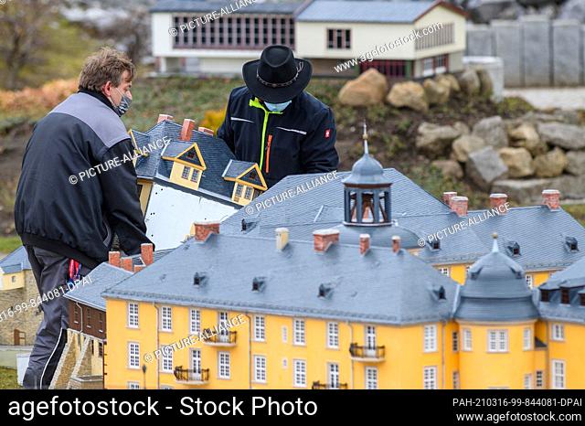 16 March 2021, Saxony-Anhalt, Wernigerode: Employees of the citizen and miniature park Wernigerode build up the model of the castle Blankenburg
