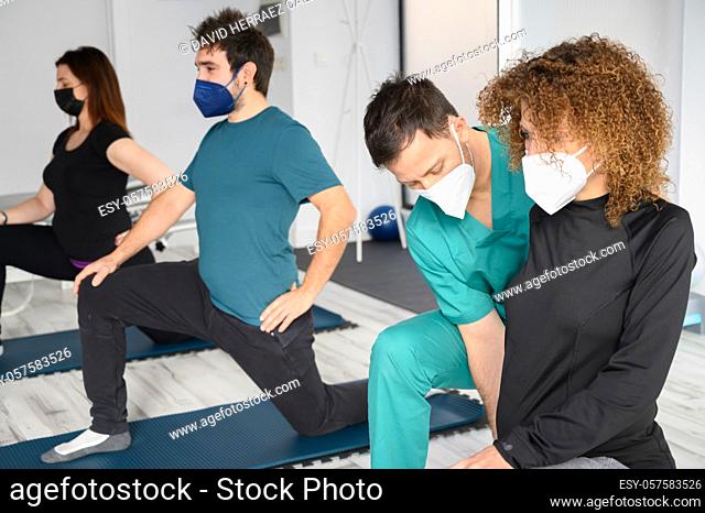 Group of doctor and patients in a rehab center wearing facemasks while doing their physiotherapy. High quality photo