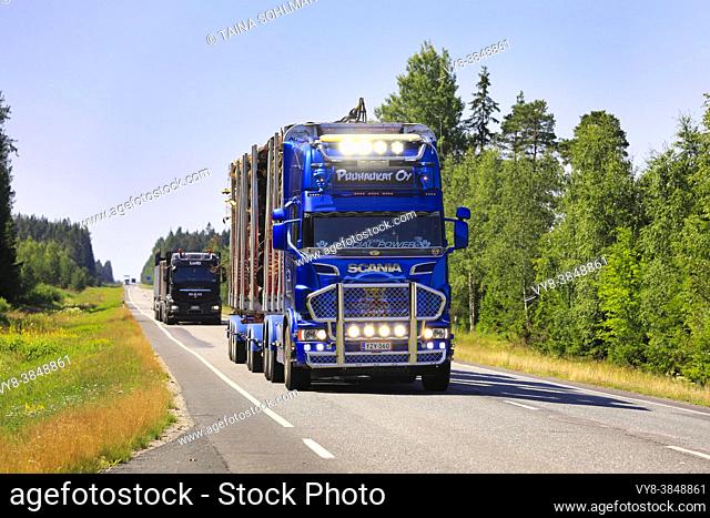 Customised Scania R620 logging truck of Puuhaukat Oy hauls wood load along highway 10, auxiliary lights briefly on. Koski Tl, Finland