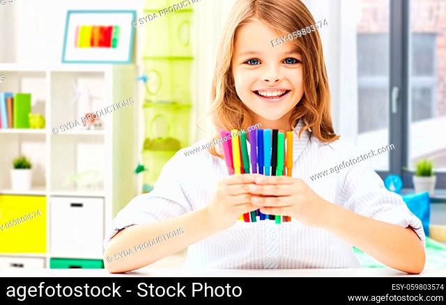 smiling student girl with felt-tip pens at home