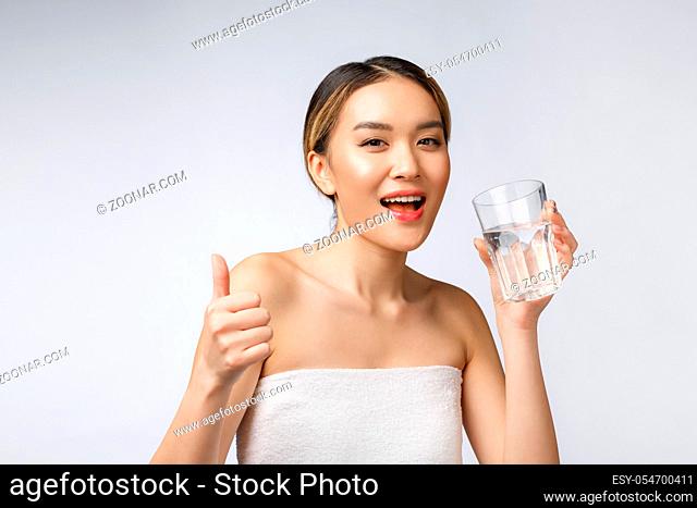 relaxed young smiling woman drinking clean water