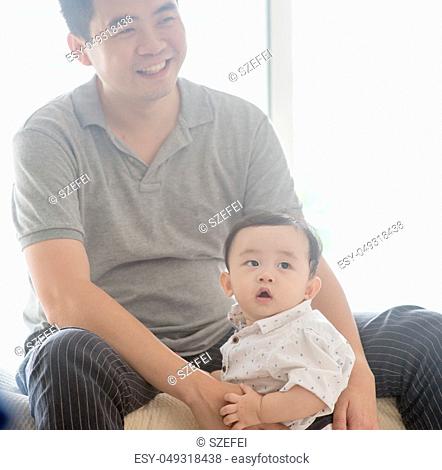 Happy Asian family at home. Father babysitting child, living lifestyle indoors
