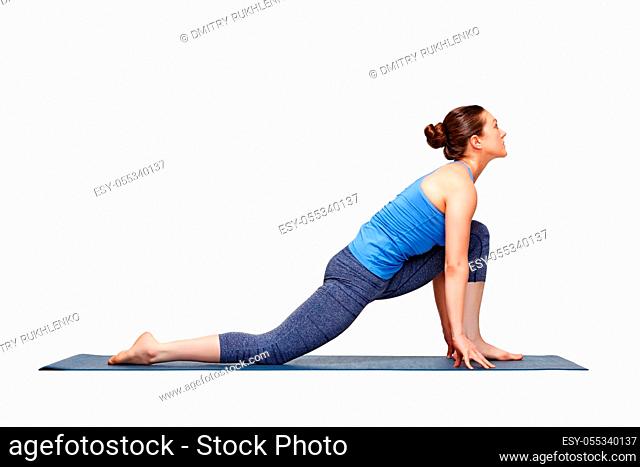 Beautiful sporty fit yogini woman practices yoga asana Anjaneyasana - low crescent lunge pose variation in surya namaskar in studio isolated on white