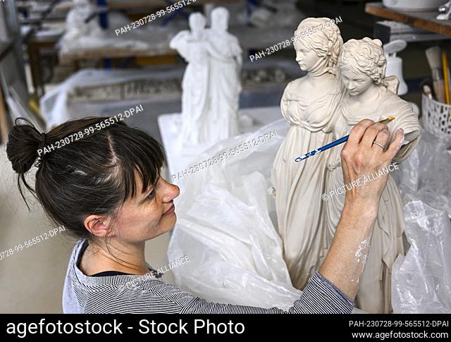 25 July 2023, Berlin: At the Königliche Porzellan-Manufaktur Berlin, manufactorer Anja Sonn removes so-called casting seams from the princess group
