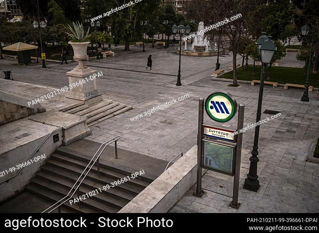11 February 2021, Greece, Athen: A woman walks across empty Syntagma Square. Since Thursday morning the greater Athens area has once again been subject to a...