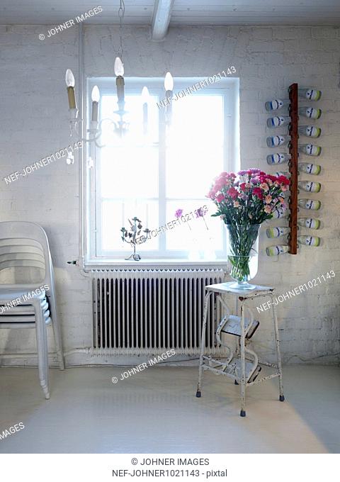 Flower vase kept on stool near window