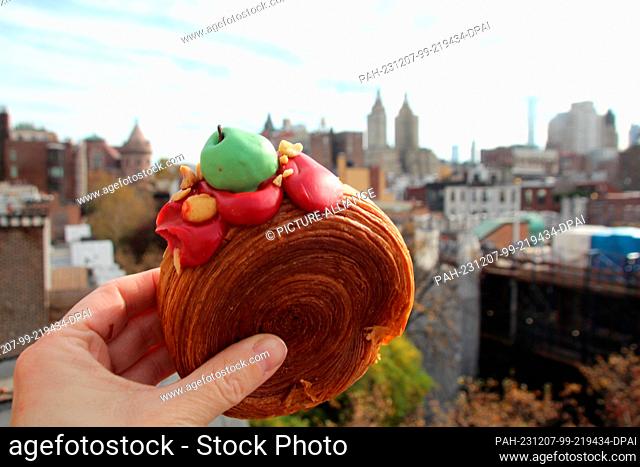 17 November 2023, USA, New York: A woman holds a ""Suprême"" - a kind of croissant filled with apple-caramel cream. (to dpa-KORR ""Ten years ago