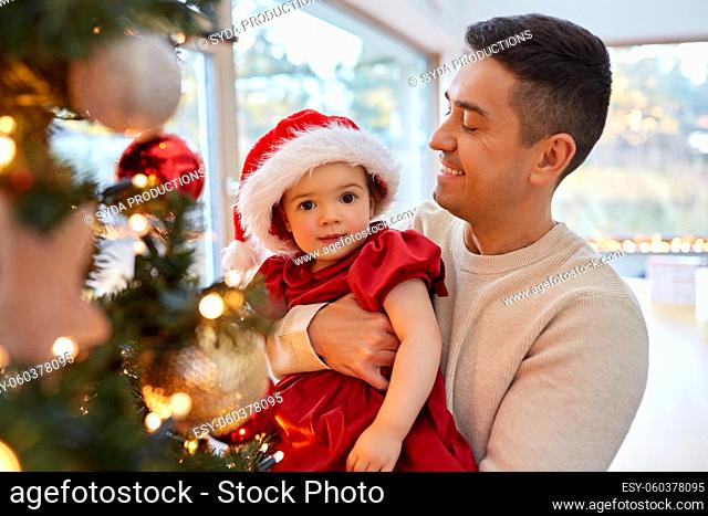 happy father and baby girl decorate christmas tree
