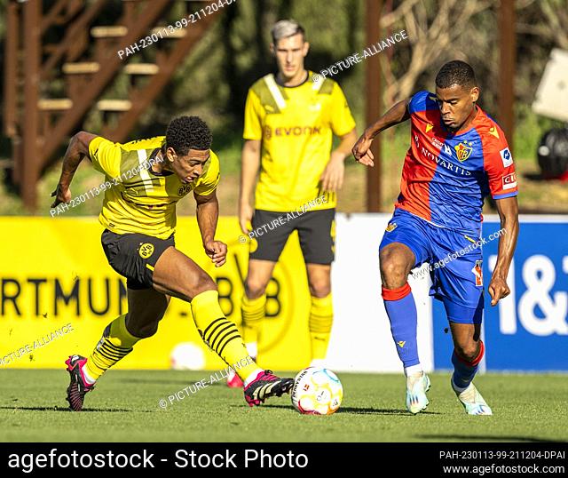 13 January 2023, Spain, Marbella: Soccer: Test matches, Borussia Dortmund - FC Basel. Dortmund's Jude Bellingham (l) and Basel's Andy Diouf fight for the ball