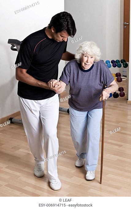 Therapist Helping Patient to walk with walking stick