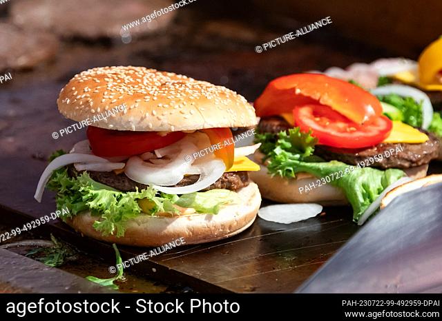 SYMBOL - 21 July 2023, Baden-Württemberg, Rottweil: Burgers are prepared at a food stand at an event in Rottweil. Photo: Silas Stein/dpa