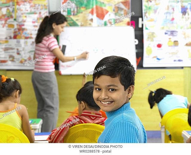South Asian Indian boy looking behind in nursery school MR
