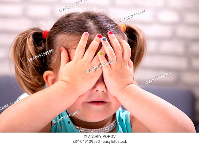 Front View Of Cute Girl Covers Her Eyes With Hand Showing Colorful Nail Polish
