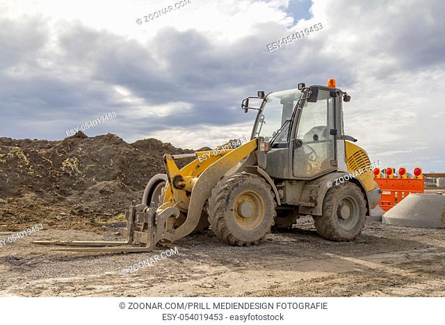 yellow loader at a loamy construction site