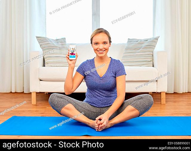 woman with smartphone having online yoga class