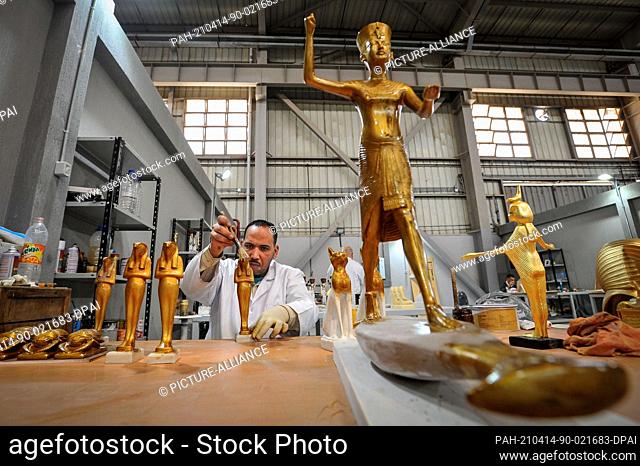 13 April 2021, Egypt, Obour City: A craftsman works on creating model replicas of the ancient Egyptian artifacts of King Tut's Treasures, at Konouz factory