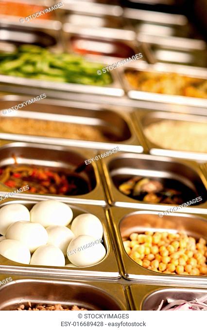 Assortment of food in trays laid out on a restaurant counter