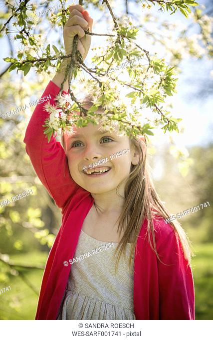 Portrait of smiling girl holding blossoming twig
