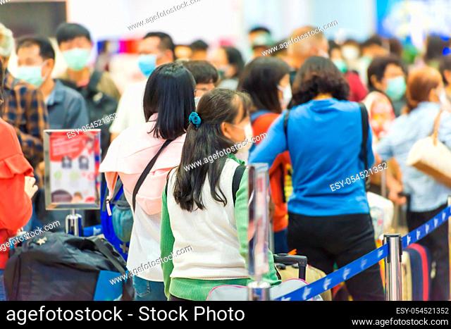 Crowd of people in masks waiting in airport during coronavirus quarantine