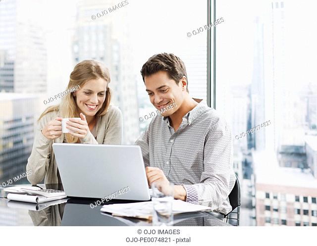 Business people using laptop together