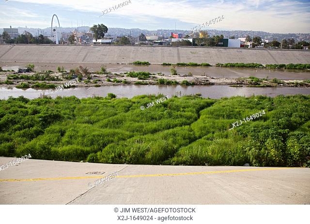 San Ysidro, California - The polluted Tijuana River as it enters the United States from Mexico  The yellow line in the foreground is the boundary between the...