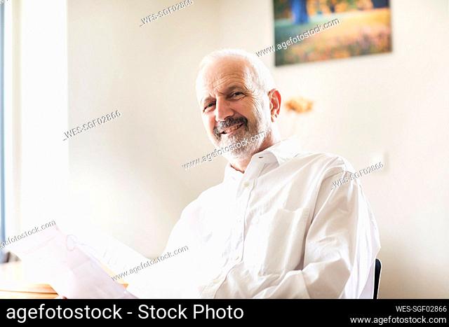 Male professional smiling while sitting at office