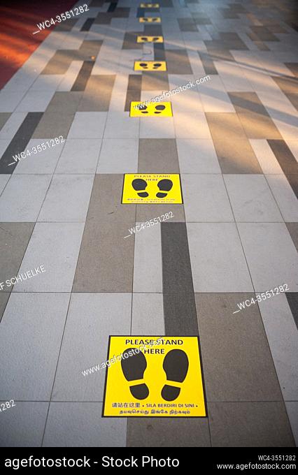 Singapore, Republic of Singapore, Asia - Marked waiting positions in front of a vending machine set up by the government with free reusable protective face...