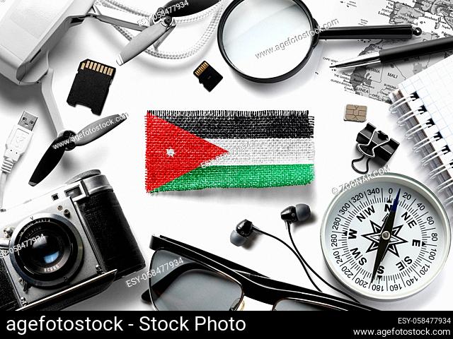 Flag of Jordan and travel accessories on a white background. The view from the top