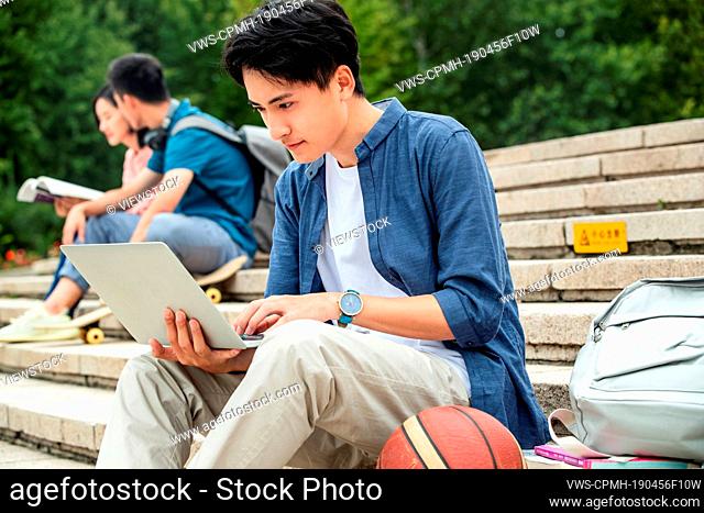 Happy college students sat on the steps of learning