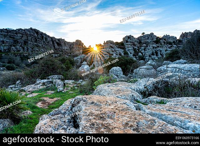 landscape with evening light with a sun star in the El Torcal Nature Reserve in Andalusia with strange karst rock formations