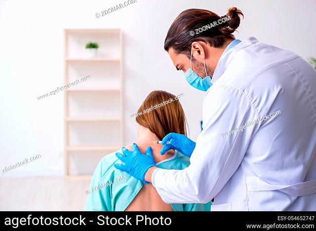 Young injured woman visiting male doctor chiropractor