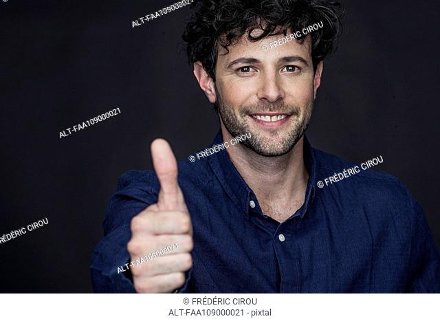Man giving thumbs up and smiling, portrait