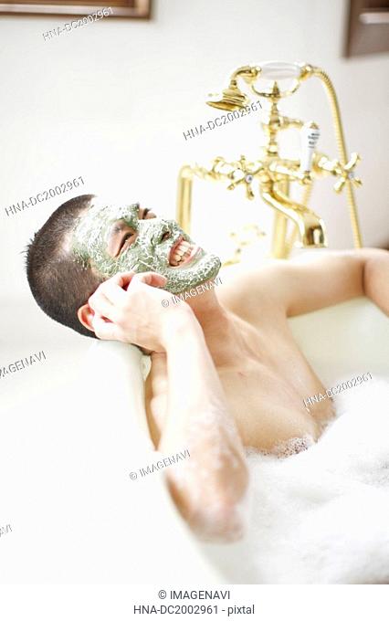 Man on Cell Phone Soaking in a Bubble Bath