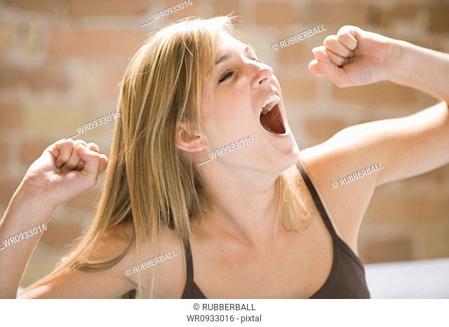 Woman yawning and stretching in bed