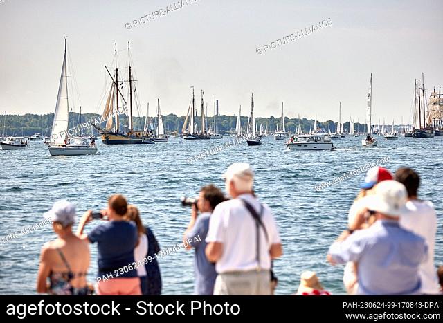 24 June 2023, Schleswig-Holstein, Kiel: Ships, boats, sailors and traditional sailing vessels take part in the Kieler Woche windjammer parade on the fjord