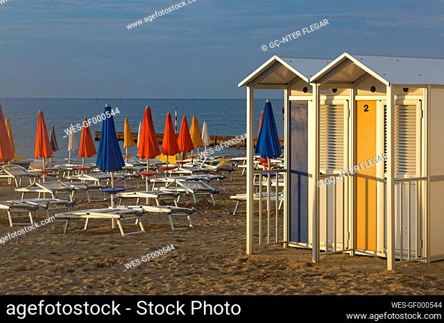Italy, Friuli-Venezia Giulia, Province of Udine, Beach with sun loungers and changing cubicles