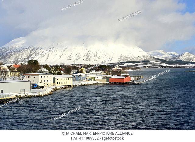 Houses and buildings from the small village Risøyhamn with a mighty snow-white overcast mountain on the island Andøya, 10 March 2017 | usage worldwide