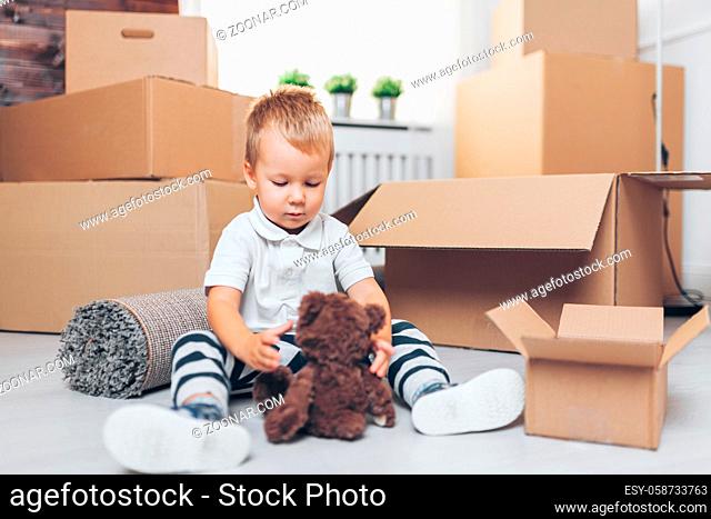 Cute toddler helping out packing boxes and moving