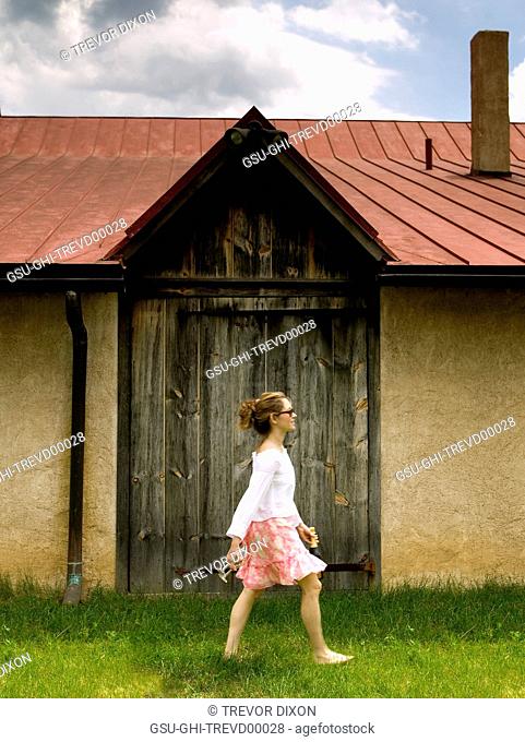 Woman Carrying Wine Bottle and Wineglasses at Winery