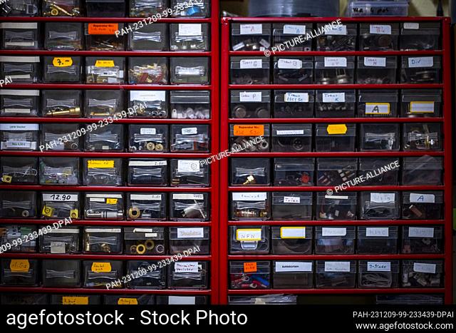 PRODUCTION - 28 November 2023, Mecklenburg-Western Pomerania, Schwerin: Shelves with electronic components and spare parts for the repair of music systems from...