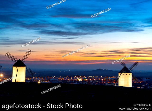 A view of the historic white windmills of La Mancha above the town of Campo de Criptana at sunset