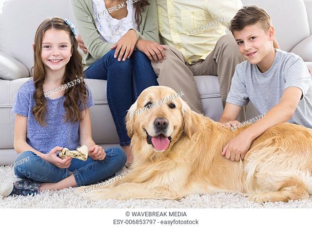 Siblings with dog and parents sitting behind